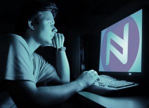 Jongen kijkt op pc naar het logo van Namecoin. 